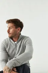 Buzo de felpa azul marino para hombre con medio cierre frontal, logo estampado en el pecho y puños. El modelo mide 1,80 m y usa talle M.