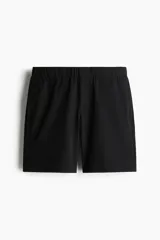 Short negro de tejido suave con cintura elástica y cordón ajustable oculto. Tiene bolsillos laterales discretos y bolsillos traseros ribeteados. Corte relajado.