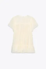 Top color crema de cuello redondo y manga corta, con detalle de bordado en el pecho y bajo con volantes. Cierre en la espalda con abertura y botón.