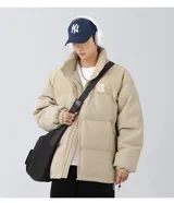 Campera puffer color beige con parte superior de pana, bordado en la espalda y tiras regulables en la cintura.