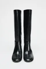 Bota negra de caña media de cuero sintético, con punta redonda y tacón ancho.