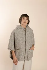 Capa color crudo de lana fina sin teñir, con capucha, cierre frontal y bolsillos con cierre.