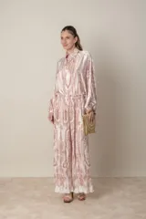 Pantalón palazzo de poliéster con estampado floral en tonos beige y rosa, cintura elastizada y corte plisado.