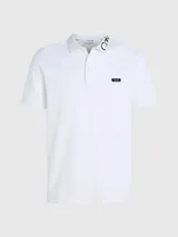 Chomba blanca de piqué elástico, corte slim y manga corta. Presenta cuello clásico con dos botones, letras bordadas con el logo en el cuello y logo de Calvin Klein bordado en el pecho.