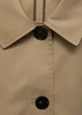 Chaqueta color beige de corte recto con cuello camisero, cierre frontal con botones y mangas largas.