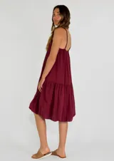 Vestido corto color marrón, con breteles finos, escote recto y corte holgado con volados en el ruedo.