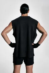 Musculosa deportiva negra sin mangas de punto suave con efecto lavado, corte holgado, cuello redondo ribeteado, bajo recto con aberturas laterales cortas y sisas sin rematar.