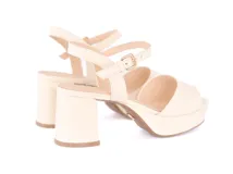 Sandalias color crema con plataforma y tacón cuadrado. Tira delantera ancha y pulsera al tobillo con hebilla dorada.