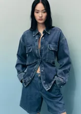 Short de algodón estilo tejano vaquero, color azul medio, de tiro medio y diseño recto con pinzas delanteras.