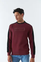 Buzo de felpa azul marino con cuello redondo y puños. Tiene mangas largas y calce regular. Presenta un logo estampado en relieve en el pecho y un logo de goma en la manga.