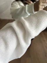 Buzo blanco de tejido de punto con cuello polo y mangas largas.