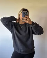 Buzo gris oscuro de corte clásico, confeccionado en 50% algodón y 50% poliéster con felpa en el interior.