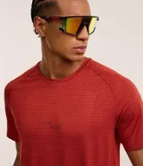 Remera deportiva color ladrillo con estampa cuadriculada y textura. Confeccionada con tecnología dry, cuello redondo y manga corta. Corte regular.