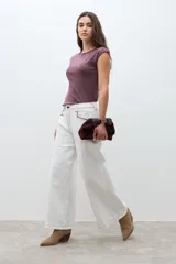 Pantalón de jean blanco crudo de tiro alto, corte culotte ancho y largo, con costuras en color rojizo.