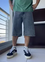 Bermuda de jean gris oscuro con lavado gastado, corte ancho y largo a la rodilla.