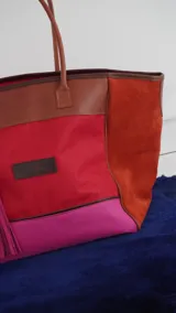 Bolso de fin de semana tipo tote bag, confeccionado en lona y gamuza, con detalles en cuero color marrón. Tiene un bolsillo interno con cierre.