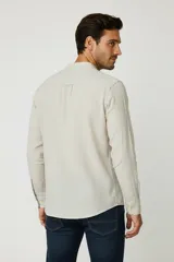 Camisa de algodón a rayas verticales azules y blancas, corte holgado, con botones y cuello mao.