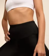 Calza legging deportiva negra con textura y brillo, de cintura alta.