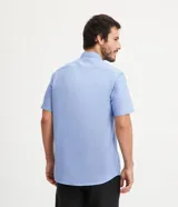 Camisa celeste de manga corta, corte comfort, con cuello abotonado y cierre frontal con botones.