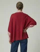 Poncho tejido de punto grueso, color mostaza/mostaza oscuro, con cuello redondo y caída amplia.