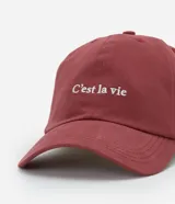 Gorra de sarga color bordó con ala curva y bordado frontal con la frase "C'est la vie".