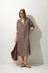 Vestido camisero midi de cuero color marrón, con cuello solapa, manga larga remangada y botones frontales.