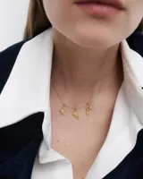 Dije dorado con forma de llave y textura efecto arena, con circonita engarzada.