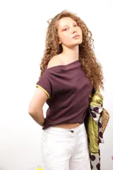 Remera color borgoña de corte crop, con mangas cortas con ribete amarillo y hombros descubiertos.