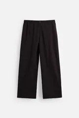 Pantalón relaxed fit color marrón oscuro confeccionado en tejido con mezcla de algodón y lino. Cintura elástica, bolsillos laterales y bolsillo trasero de plastrón. Perneras con pliegues frontales. Cierre en delantero con cremallera y botón.