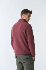Buzo polar de algodón color bordó, con cuello elevado, medio cierre frontal, bolsillo con cierre en el pecho y logo estampado.