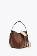 Bolso marrón formato saca con asa de mano y tira bandolera extraíble. Incluye cartera con bolsillo extraíble y cierre mediante botón imantado.