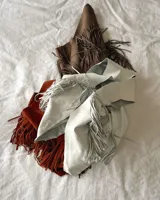 Chaleco negro de cuero vacuno con flecos largos en el frente y espalda.