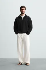 Sudadera color crema de corte recto, con cuello polo y cierre de cremallera metálica.