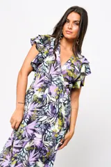 Vestido largo con estampado floral en tonos lila, verde y blanco, con escote en V, mangas cortas con volados y lazo ajustable en la cintura.