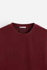 Camiseta negra de corte holgado, con cuello redondo y mangas cortas.