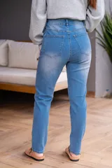 Jean de tiro alto color celeste, con cinco bolsillos, corte ajustado y cierre frontal con cremallera y botón.