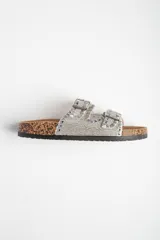 Sandalias plateadas con plataforma de corcho y doble tira con hebillas ajustables, decoradas con tachas y strass.