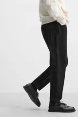 Pantalón de jean celeste de corte slim fit y tapered, con cinco bolsillos, efecto lavado y cierre frontal con cremallera y botón.
