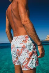Short de baño con estampado de flores y cachemira en tonos celeste, naranja y rosa. Tiene cintura elástica, cordón ajustable y bolsillo trasero con etiqueta de la marca.