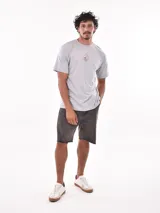 Remera negra de corte oversized con estampado circular en el pecho que incluye una palmera, una ola y la palabra 'Paradise'.