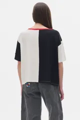 Remera oversized colorblock en rib, con mangas cortas y cuello redondo con ribete rojo.