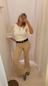 Pantalón de vestir color beige, de tiro alto, corte recto y terminación acampanada.