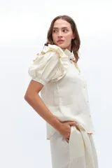 Camisa amarilla de lino con cuello mao y mangas cortas abullonadas con volados.