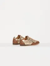 Zapatilla urbana color marrón y dorado, confeccionada en cuero vacuno con recortes en mesh.