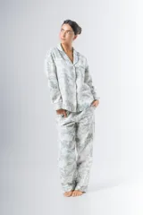 Pijama de algodón estampado con motivos de árboles y fuentes, compuesto por una camisa de manga larga con botones y un pantalón recto con elástico en la cintura.