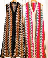 Vestido largo de tejido con diseño geométrico en tonos celeste, marrón, rojo y blanco. Tiene escote en V y aberturas laterales.