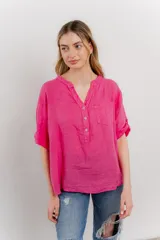 Camisa azul de lino con escote en V abotonado, bolsillo frontal y mangas 3/4 con trabilla.