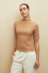 Top color crema de textura acanalada, con cuello semi alto y mangas cortas.