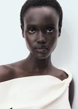 Top entallado color crema, sin mangas, con diseño asimétrico de palabra de honor y fruncido lateral.