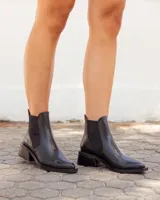 Botinetas estilo Chelsea de cuero negro con textura grabada, elásticos laterales y taco cuadrado de altura media.